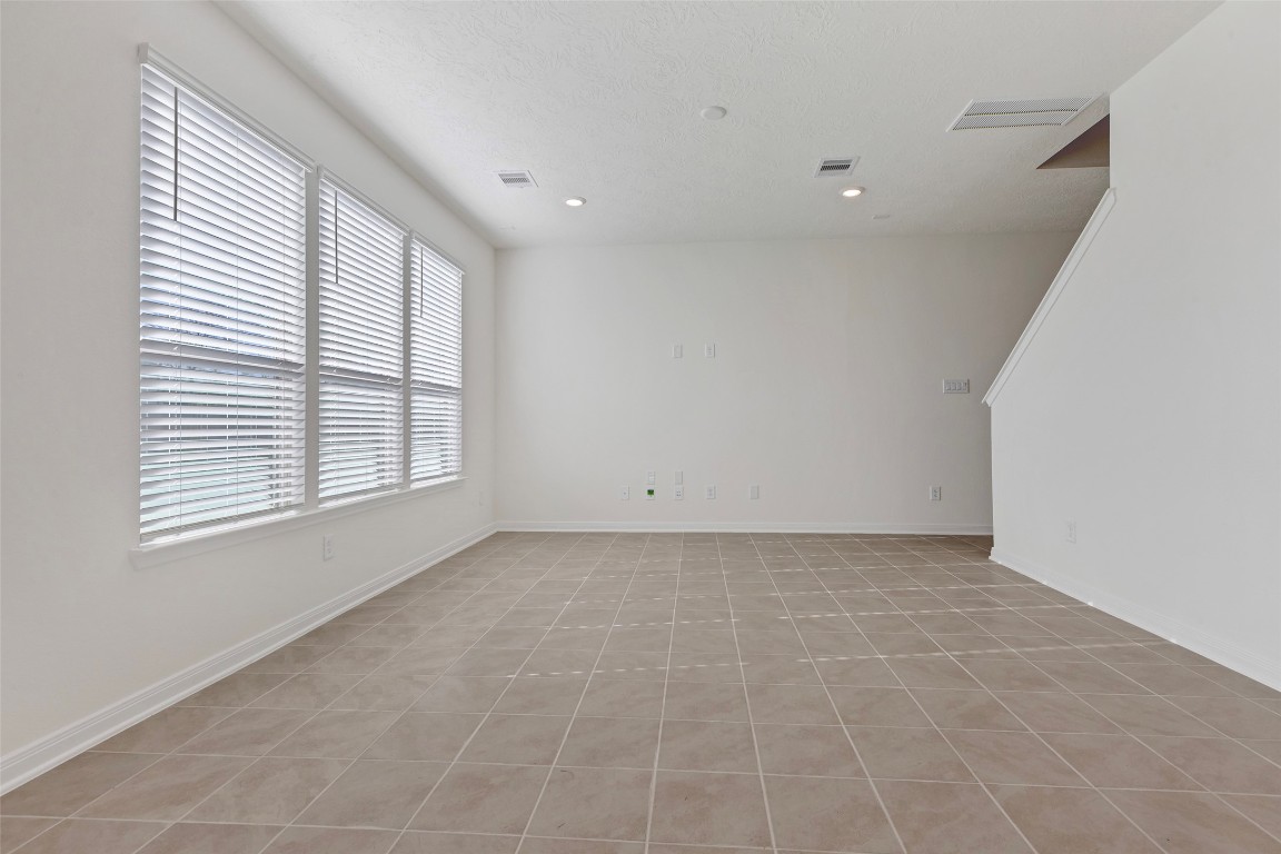 9423 Castillo Court Magnolia, TX 77354 - Photo 10 of 28 The spacious living room is filled with natural light, featuring multiple windows that create an open and airy feel.