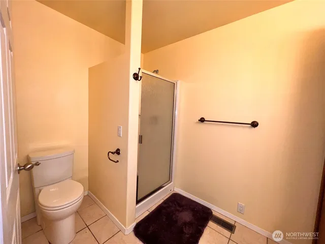 a bathroom with a toilet and a shower