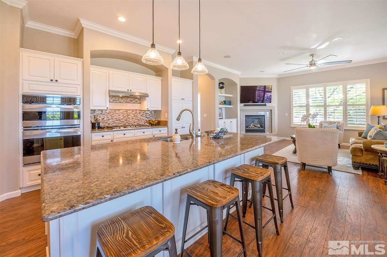 4935 Gila Bend Road Reno, NV 89511 - Photo 4 of 21 a kitchen with stainless steel appliances granite countertop a table chairs and a view of living room