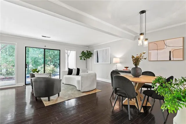a living room with furniture a potted plant and a large window