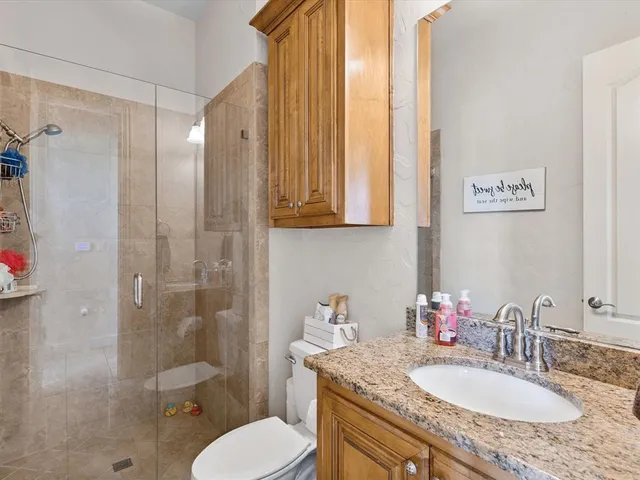 a bathroom with a granite countertop sink toilet and shower