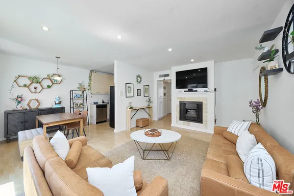 a living room with furniture a flat screen tv and a fireplace