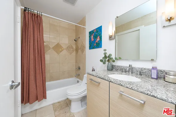 a bathroom with a granite countertop sink toilet and shower