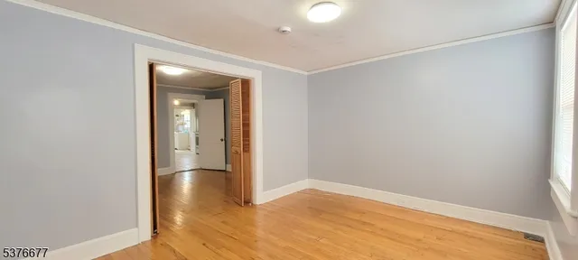 an empty room with wooden floor and closet