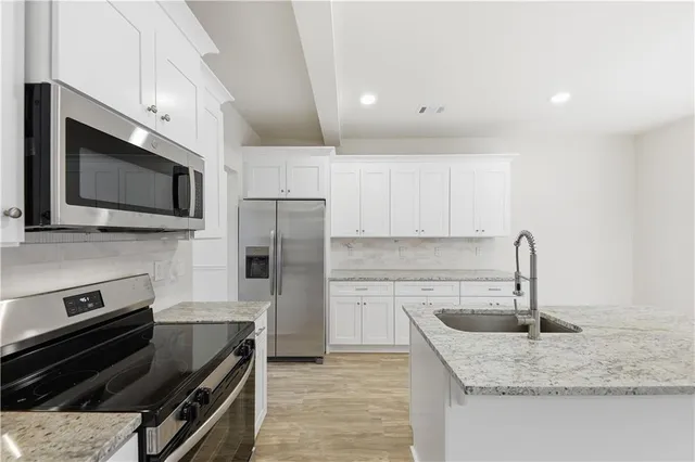 a kitchen with a sink stainless steel appliances and cabinets