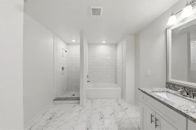 a bathroom with a granite countertop sink a toilet and shower