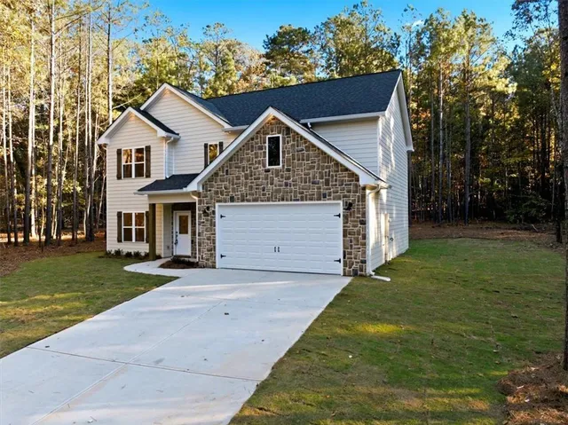 a front view of a house with a garden and yard