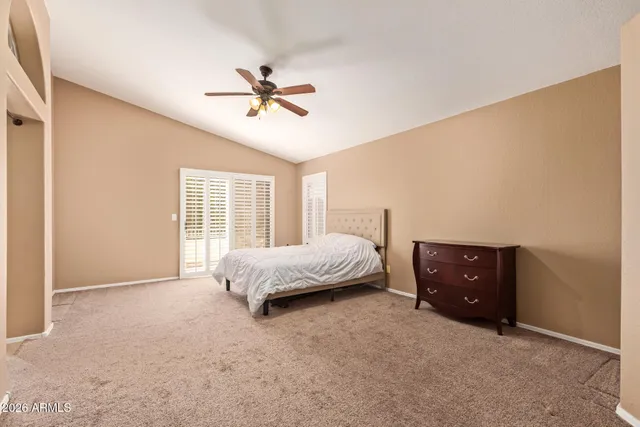a spacious bedroom with a bed and a ceiling fan