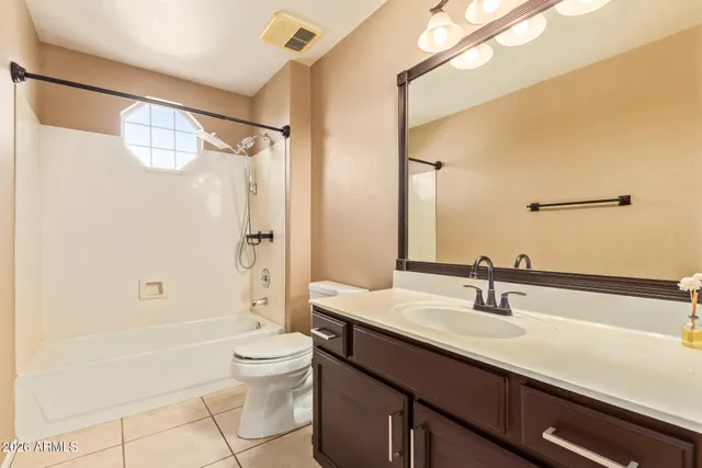 a bathroom with a granite countertop sink a toilet and a mirror