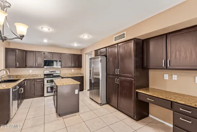 a kitchen with stainless steel appliances granite countertop a refrigerator stove top oven and sink