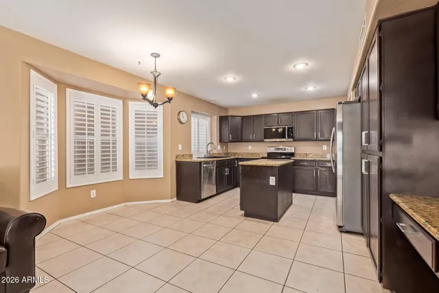 a kitchen with stainless steel appliances kitchen island granite countertop a sink counter space cabinets and a counter top space