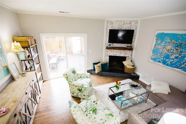 a living room with furniture a fireplace and a flat screen tv