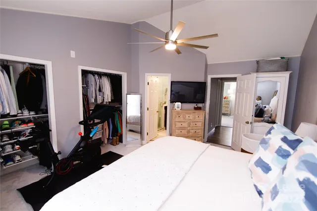 a bedroom with a bed and a flat tv screen on dresser