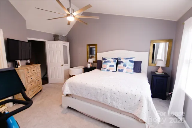 a bedroom with a bed and a flat tv screen on the dresser
