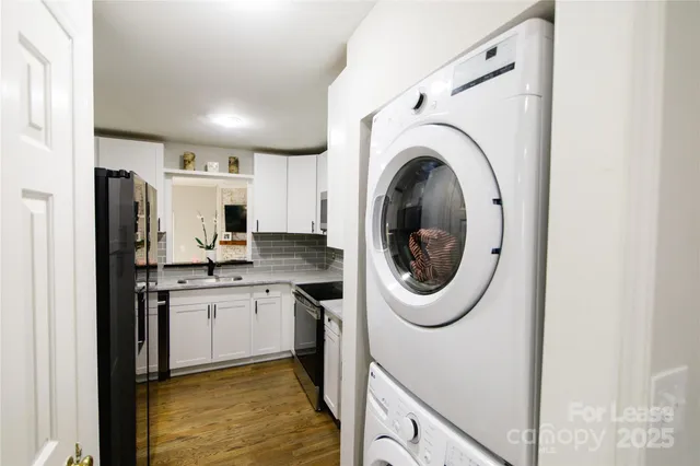 a kitchen with stainless steel appliances granite countertop a sink a stove a washer and dryer