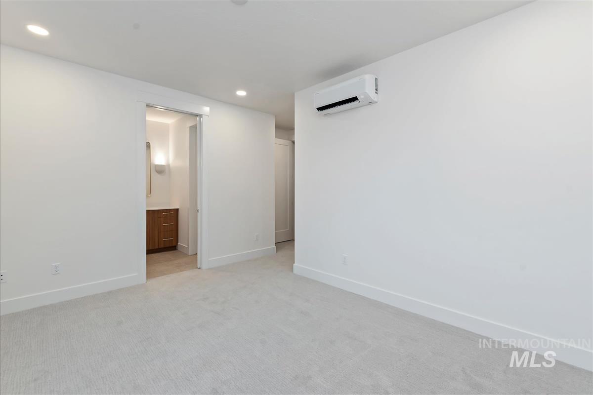 3213 West Moore Street Boise, ID 83702 - Photo 24 of 32 Spacious room featuring light-toned carpeting, recessed lighting, and a wall-mounted mini-split HVAC unit