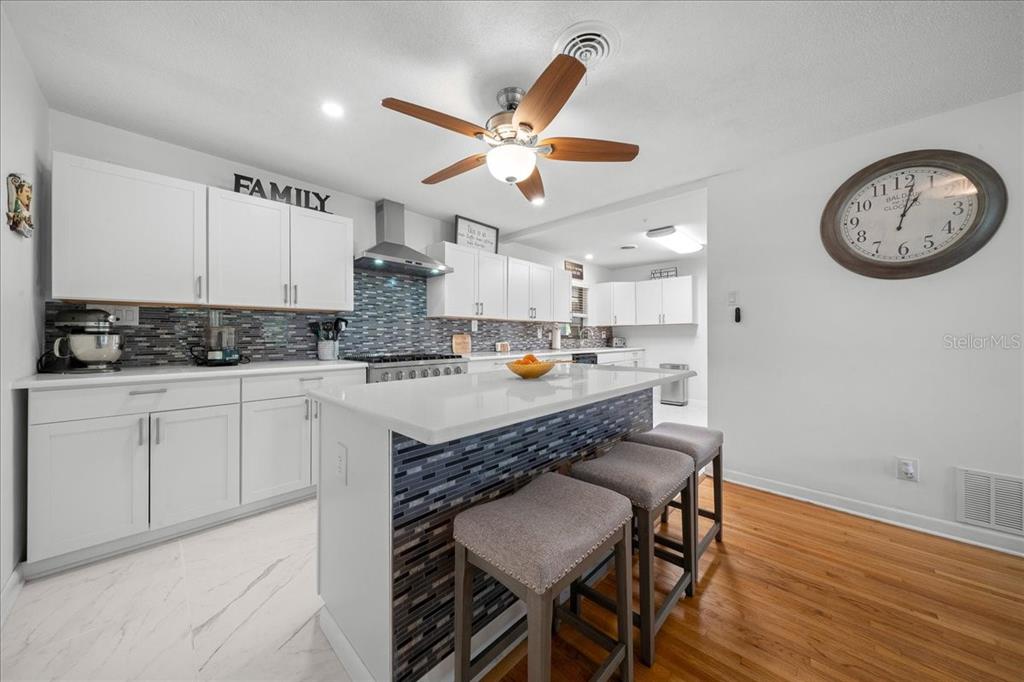 4367 Northeast 11th Street Ocala, FL 34470 - Photo 9 of 24 a kitchen with a table chairs a sink dishwasher a dining table and chairs with wooden floor