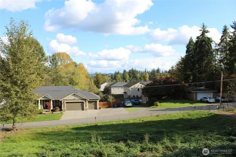 a view of house with garden and tall trees