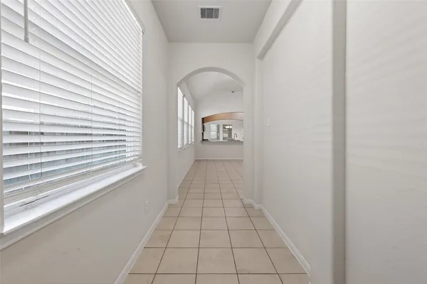 a view of an empty room with a chandelier fan