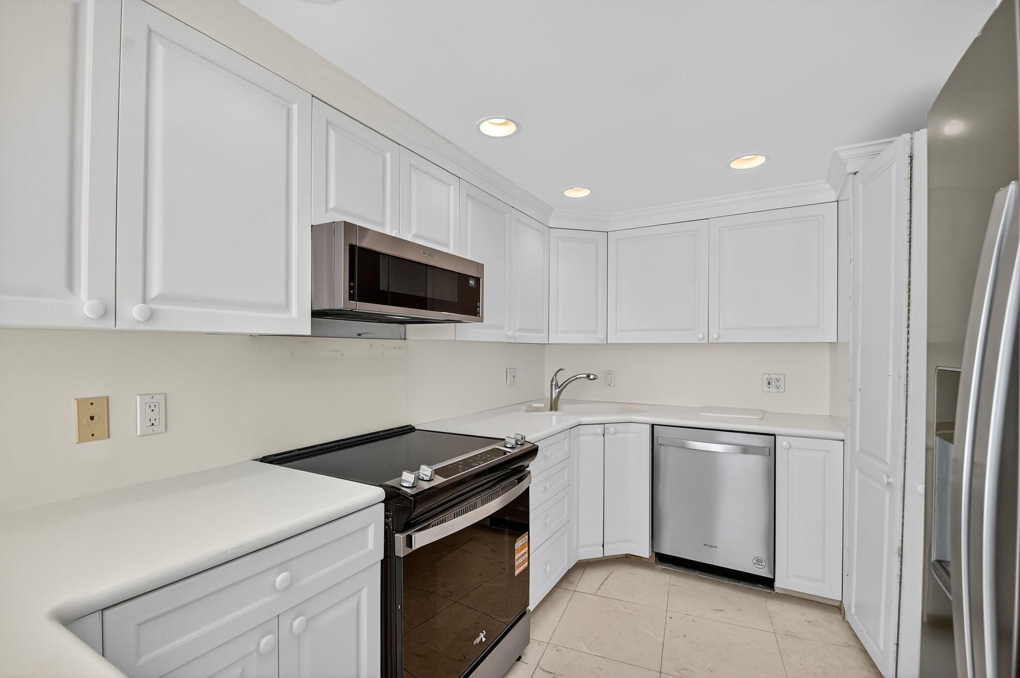 2780 South Ocean Boulevard, Unit 703 Palm Beach, FL 33480 - Photo 30 of 44 a kitchen with a sink and a stove top oven with white cabinets