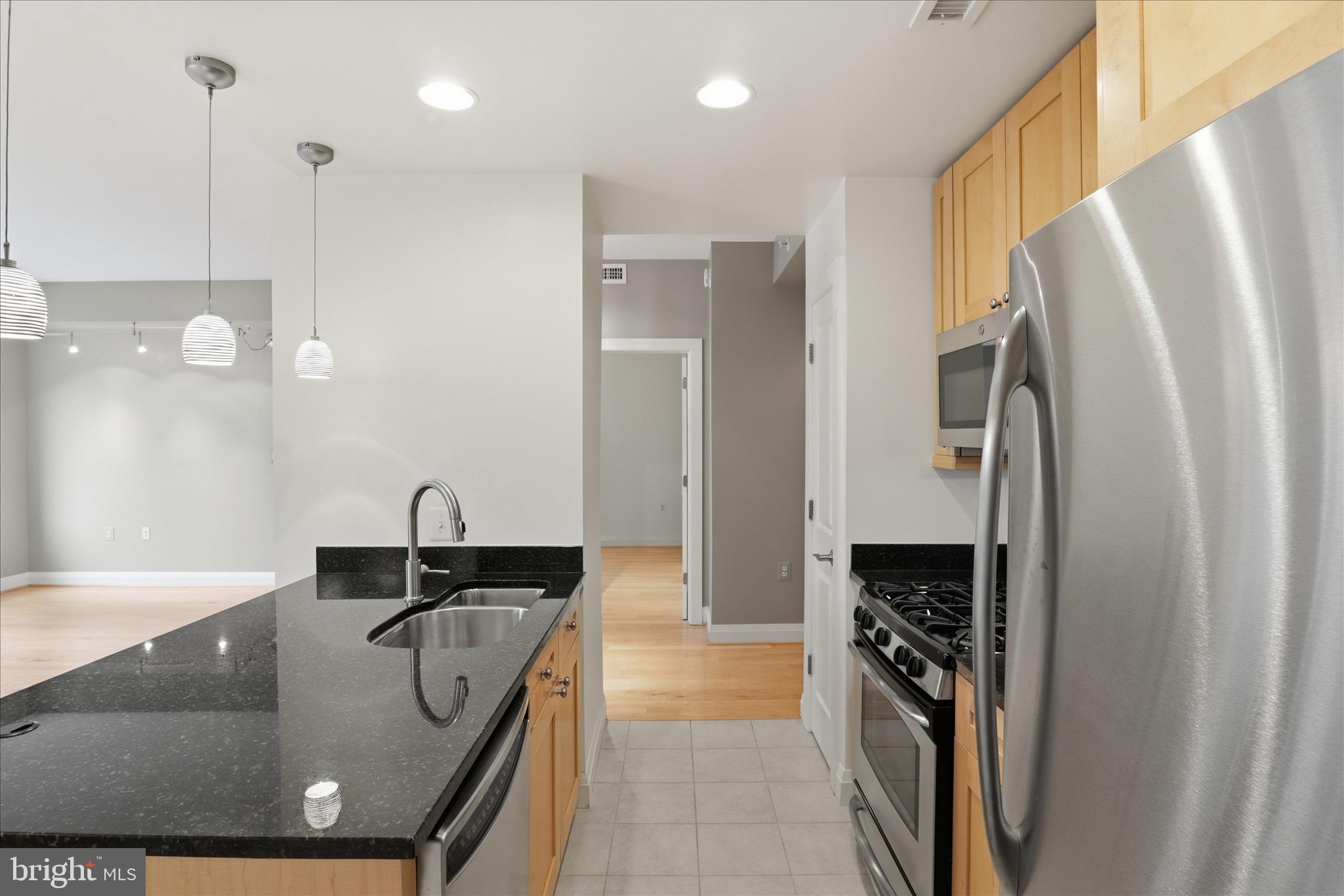 11990 Market Street, Unit 216 Reston, VA 20190 - Photo 21 of 41 a kitchen with stainless steel appliances granite countertop a sink a stove a refrigerator and a refrigerator