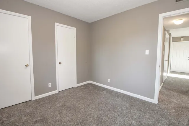 an empty room with windows and closet