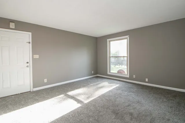 a view of a refrigerator in kitchen and white cabinets