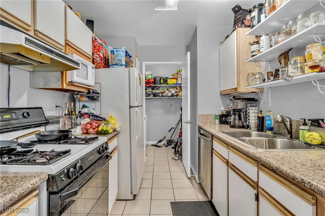 2200 South Fort Apache Road, Unit 1007 Las Vegas, NV 89117 - Photo 12 of 30 Kitchen with white appliances, white cabinets, light countertops, open shelves, and a sink