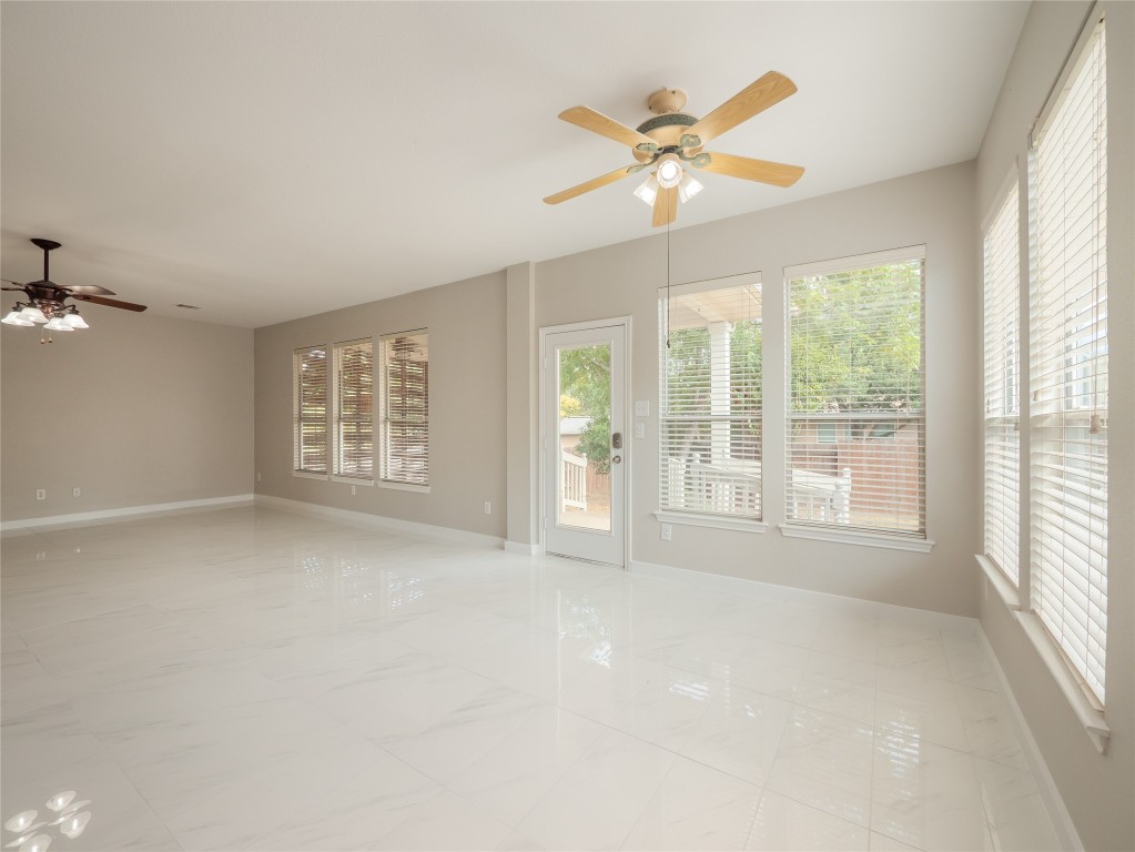 406 Primavera Loop Kyle, TX 78640 - Photo 11 of 38 an empty room with windows and chandelier fan