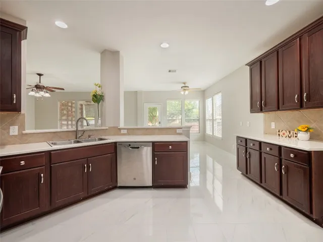 a large kitchen with stainless steel appliances granite countertop a sink dishwasher stove and cabinets