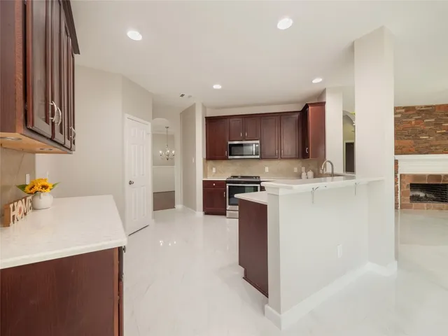 a kitchen with kitchen island granite countertop a sink a stove and a refrigerator