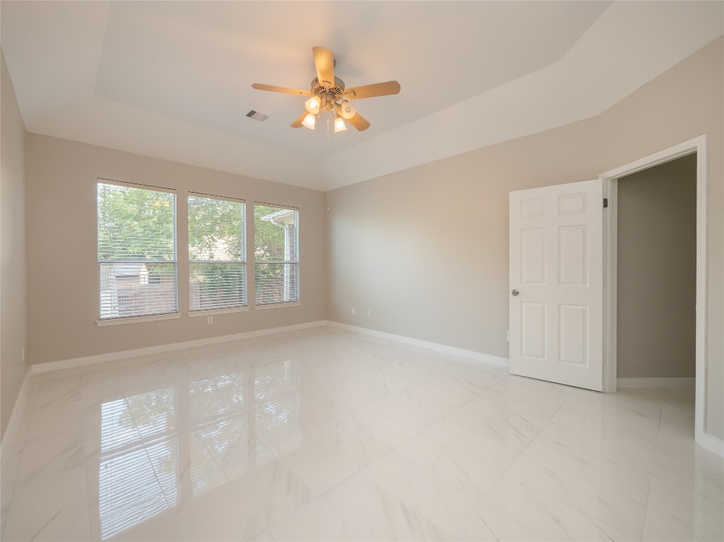 406 Primavera Loop Kyle, TX 78640 - Photo 17 of 38 an empty room with chandelier fan and windows
