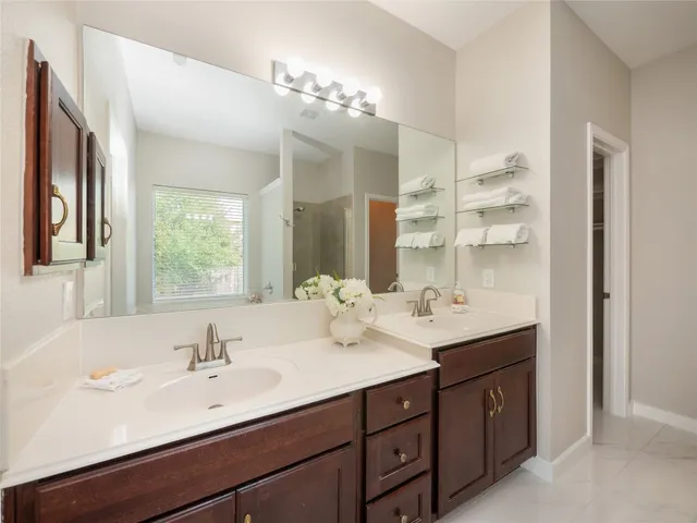 a bathroom with a sink double vanity granite and a mirror