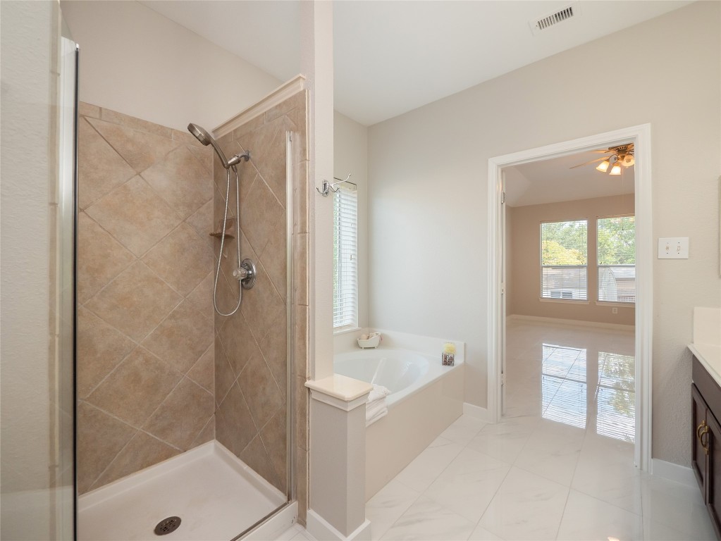 406 Primavera Loop Kyle, TX 78640 - Photo 19 of 38 a bathroom with a tub shower and a sink