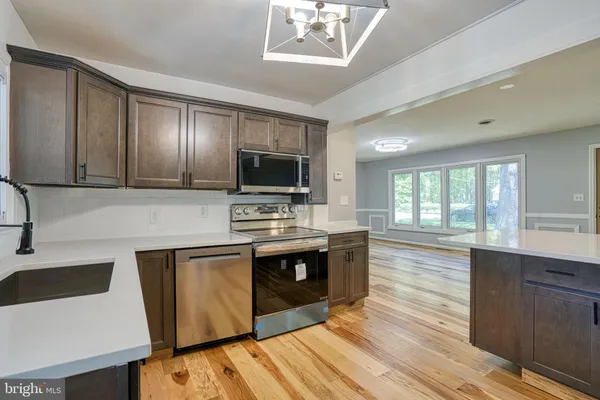 a kitchen with stainless steel appliances a stove a sink and a microwave