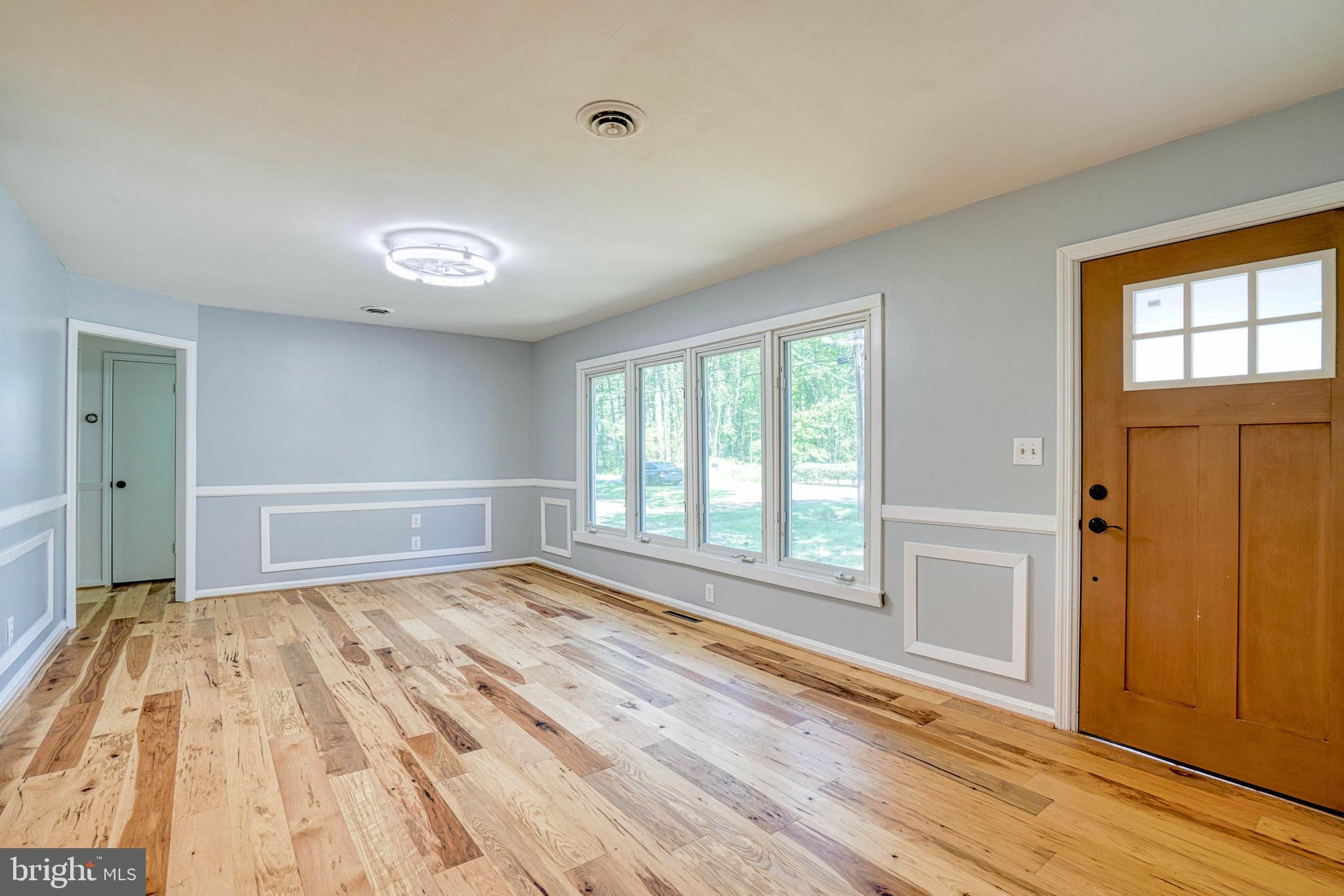 10 Bay View Avenue Cambridge, MD 21613 - Photo 4 of 28 an empty room with wooden floor and windows