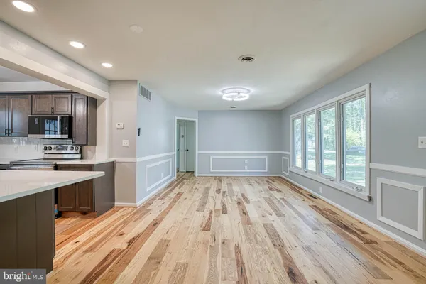 a open kitchen with kitchen island wooden floors and stainless steel appliances
