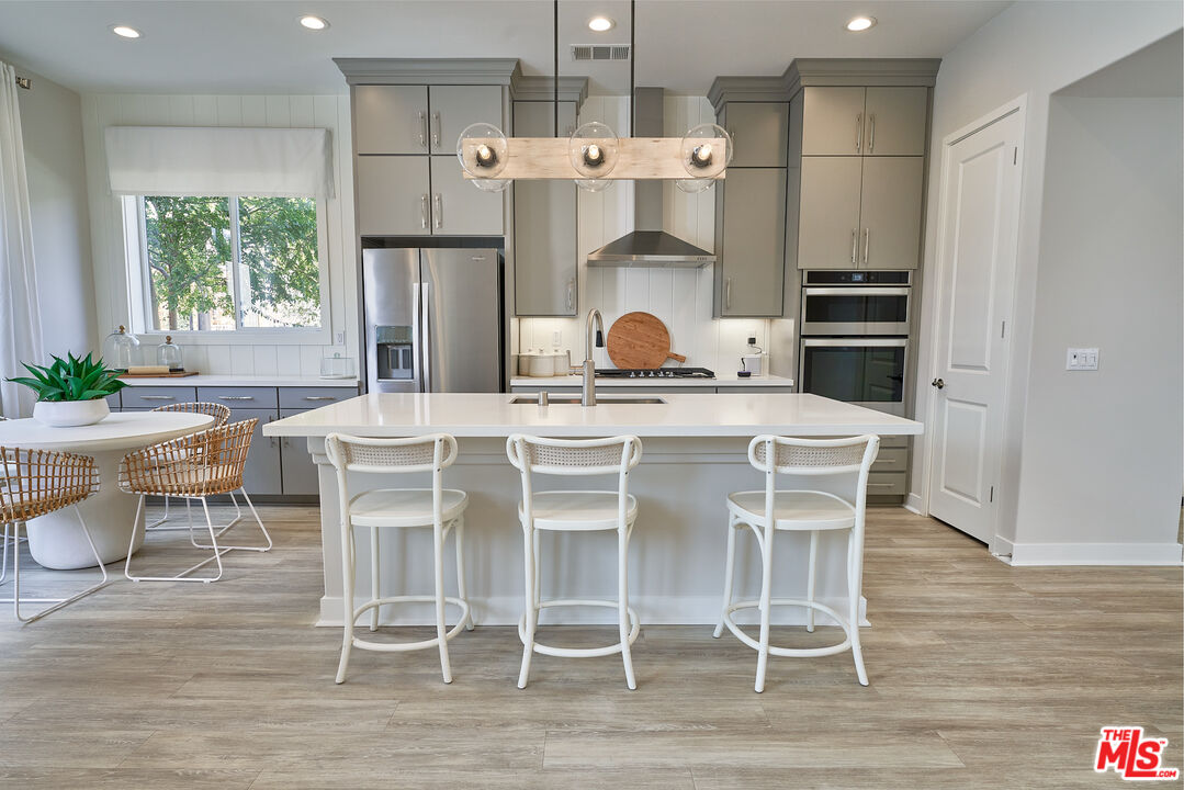 525 Daniel Freeman Circle Inglewood, CA 90301 - Photo 8 of 39 a kitchen with stainless steel appliances a table chairs and a refrigerator