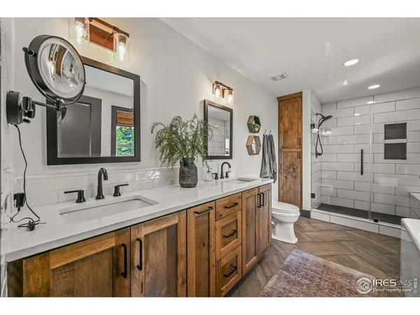 a en suite bathroom with a double vanity sink and a mirror