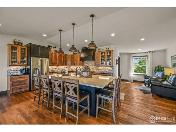 a kitchen with stainless steel appliances granite countertop a table chairs stove and cabinets