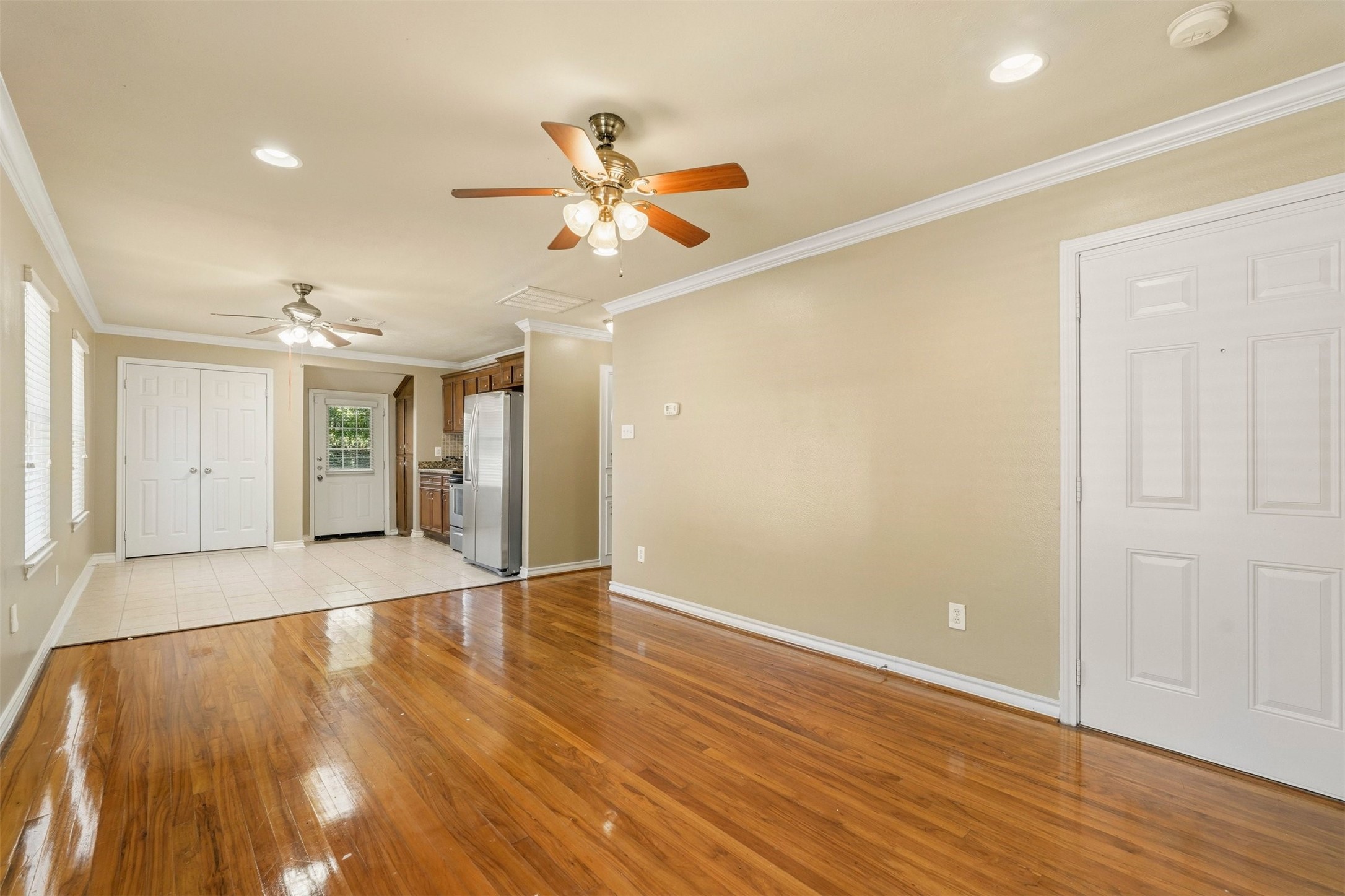3445 Nathaniel Brown Street Houston, TX 77021 - Photo 5 of 19 a view of an empty room with wooden floor and a ceiling fan