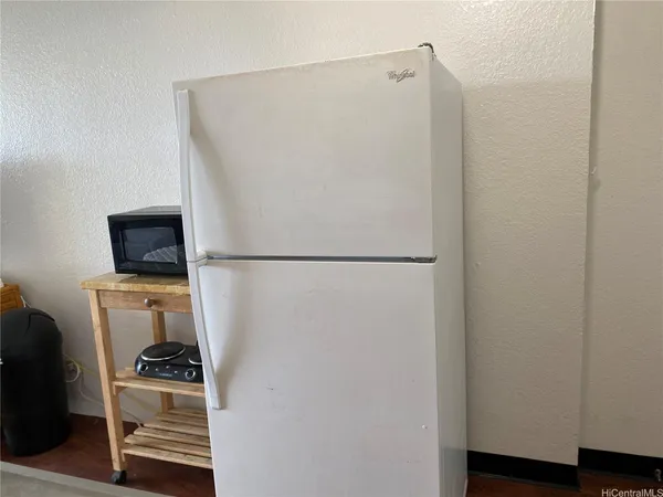a room with a refrigerator and a stove top oven