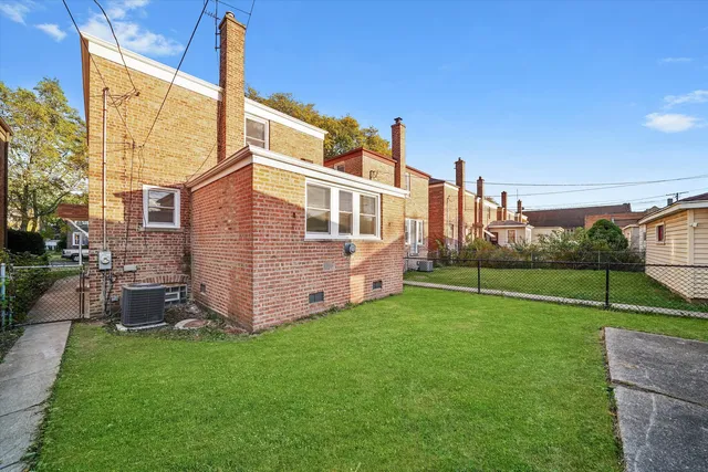 a view of a house with backyard and a tree