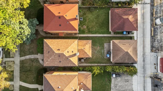 an aerial view of a house with a yard and a large tree