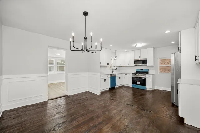 a kitchen with stainless steel appliances kitchen island a refrigerator sink and cabinets