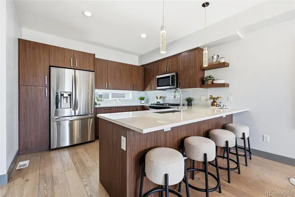 a kitchen with kitchen island a refrigerator stove a sink and a microwave