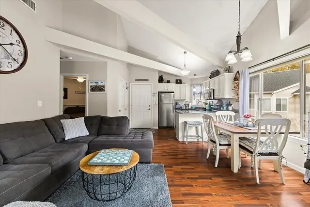 a living room with furniture and a dining table with kitchen view