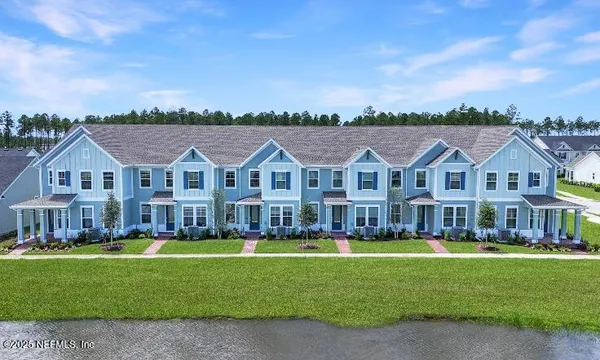 a view of a big house with a big yard and large trees