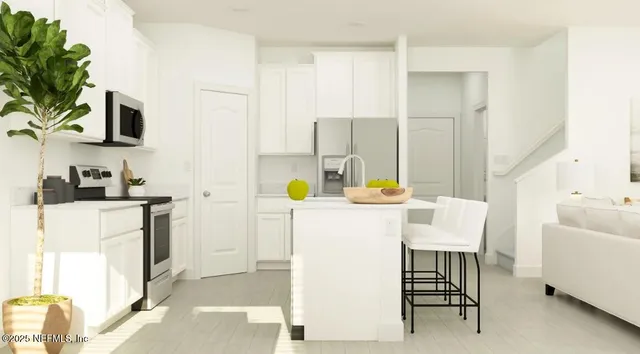 a white kitchen with a table chairs and a refrigerator