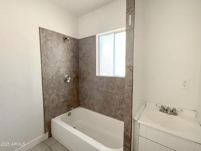 an empty room with windows and ceiling fan